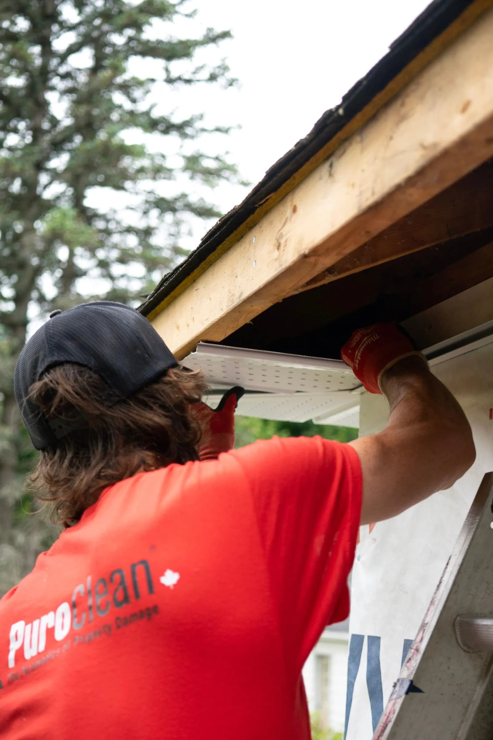 Exterior contractor installing or repairing gutter work on a house.