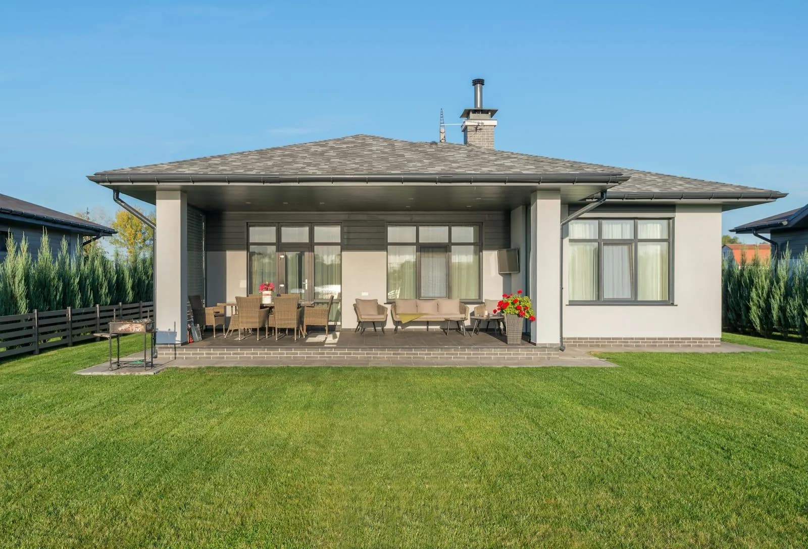 Backyard patio behind a residential home with lawn and outdoor living space.